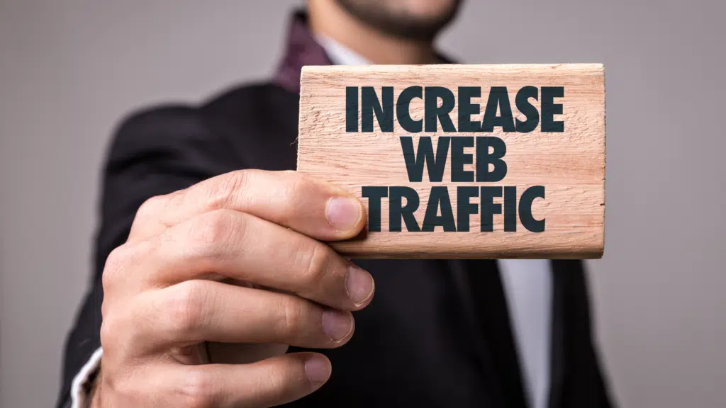 Business professional holding a sign that says increase web traffic to improve online visibility